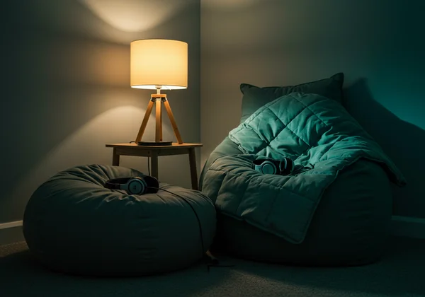A calm room with soft lighting, weighted blanket, and headphones